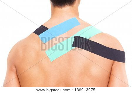 Young muscular man with kinesiotaping on the shoulders and back, isolated on white background