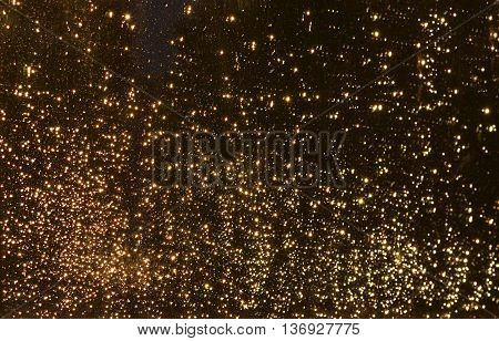 Sparks. Christmas background. Orange sunset reflection on a window