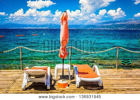 View at beach in Supetar, touristic destination on Adriatic sea, with view at city of Split in background.