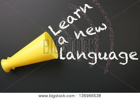megaphone with message learn a new language on the blackboard