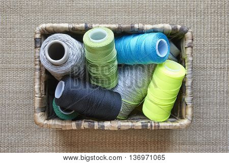 Multicolored sewing thread detail on a basket. Horizontal