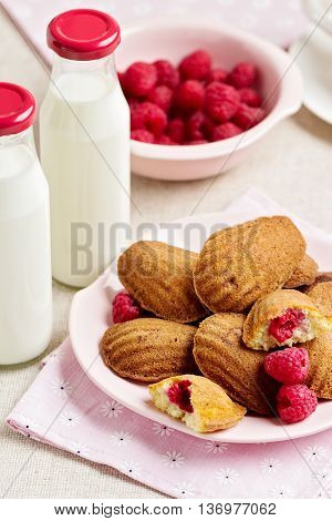 French pastry Madeleine with raspberries. Selective focus.