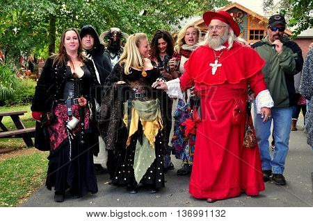 Mount Hope Pennsylvania - October 17 2015: Merrymakers in splendid medieval clothing accomopany a Cardinal on a stroll around the annual Pennsylvania Renaissance Faire