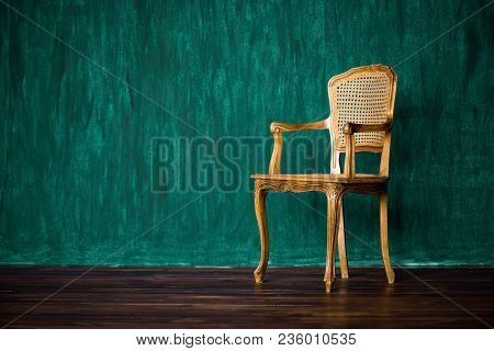 Old Chair On A Green Wall Background