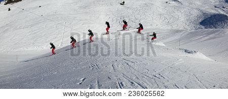 Young, Female Skier, Jumping In The Air On Skis, On A Sunny Day In Meribel, The French Alps.