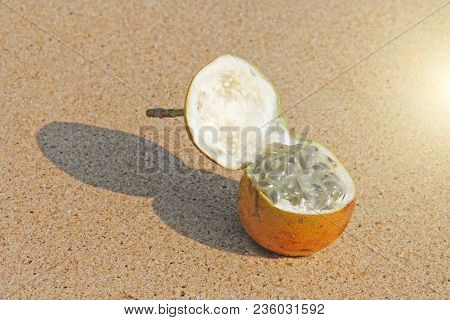One Orange Open Passion Fruit With Seeds. Passion Fruit Closeup On The Beach, On The Sand And On The
