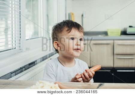 Handsome Boy Shaggy And Shkod Holds A Sausage In His Hand And Looks Away