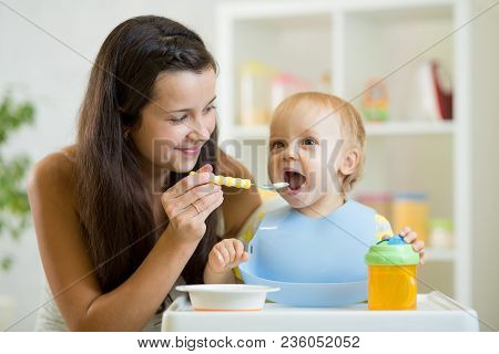 Mom Feeds Baby From Spoon. Little Boy Eats Healthy Food