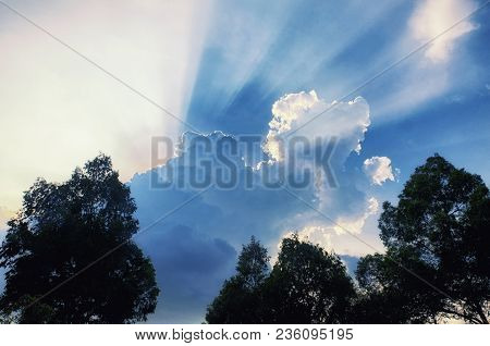 Sun Light Beams Escaping Behiind Large White Puffy Clouds In Vietnam In Southeast Asia.