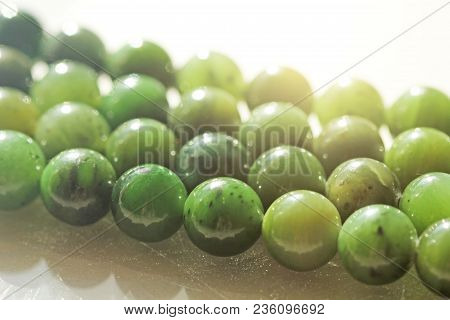 Natural Green Jade Nephrite Mineral Stones Beads. Green And Grassy Natural Background Made Of Round 