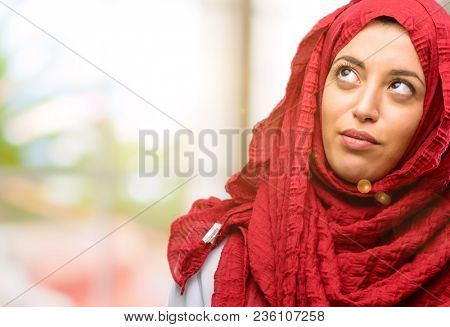 Young arab woman wearing hijab making funny face fooling