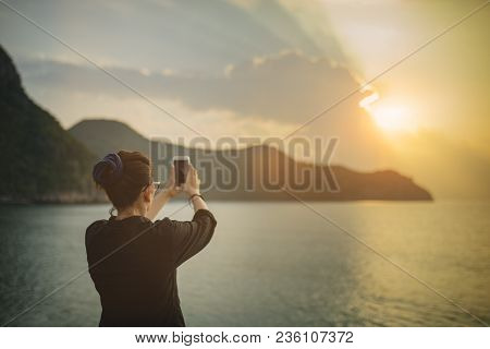 Woman Taking Sun Rise Photograph By Smart Phone At Sea Side