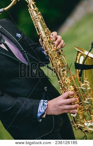 A Saxophonist Plays The Saxophone. Hands Close Up