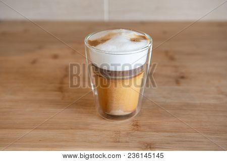 Multilayer Coffee Or Cappuccino In A Glass Cup On Wooden Table.