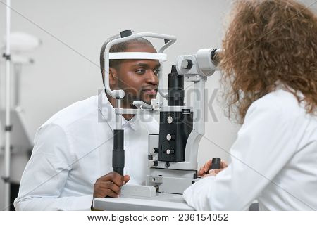 Sideview Of Patient Looking At Apparatus During Vision Checking With Oculist.