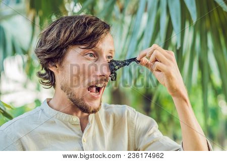 Happy Man With Black Mask On The Face. Photo Man Receiving Spa Treatments. Beauty Skin Care Concept.