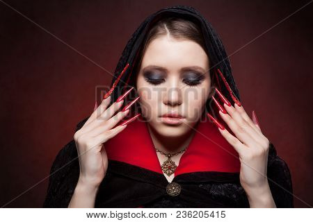 Vintage Style Portrait Of Young Beautiful Vampire Woman With Gothic Halloween Makeup. Manicured Red 