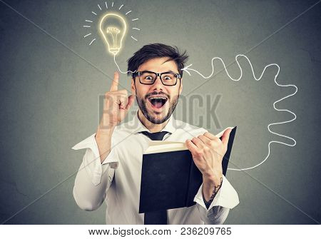Amazed Young Man In Glasses Reading A Book Comes Up With An Idea