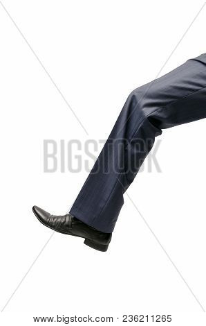 A Huge Human Foot Close Up Isolated On White Background. A Big Businessman Leg In Trousers And Shoes