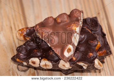 Dark And Milk Chocolate With Nuts On A Wooden Background