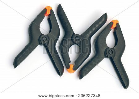 Three Black Plastic Clamps For Construction Work On White Background