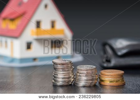Mortgage Copncept. Money And Coins In Front Of A House.