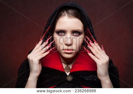 Vintage Style Portrait Of Young Beautiful Vampire Woman With Gothic Halloween Makeup. Manicured Red 