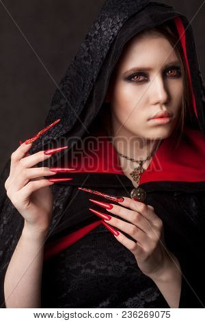 Vintage Style Portrait Of Young Beautiful Vampire Woman With Gothic Halloween Makeup. Manicured Red 