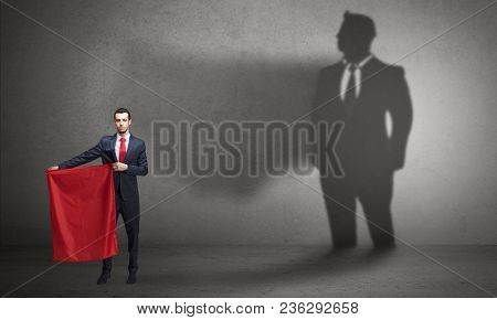Businessman standing with red cloth on his hand and his shadow on the background