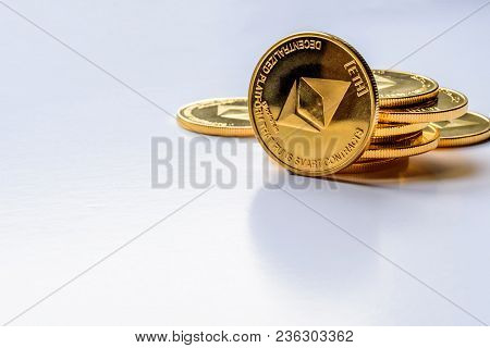 Golden Virtual Money Ethereum Crypto Currency Coins Stacked On Bright Background.