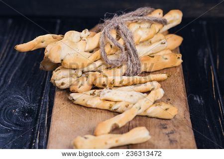 Crispy Grisini With Olive On Wooden Plate In Studio