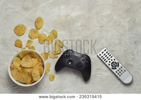 Remote Control From The Tv, Bowl With Chips, Gamepad On The Light Stone Background. The Concept Of C