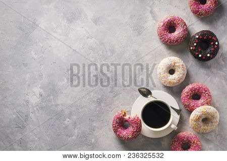 Sone Pink And White Donuts With Cup Of Coffee Over Grey Stone Texture, Top View, Copy Space
