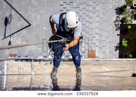 Above View On Young Man, Industrial Climber At Work, He Washing Building Facade.