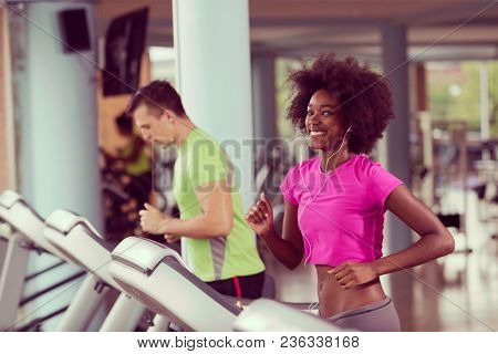 young people exercisinng a cardio on treadmill running machine in modern gym