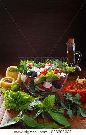Greek Salad With Olive Oil In A Glass Bowl. Fresh Vegetables And Herbs. A Place For Inscriptions.