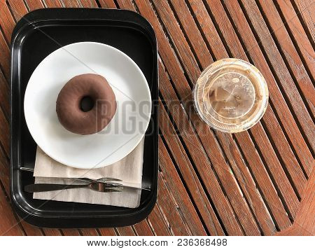 Chocolate Dougnuts Served With Iced Coffee On Wood Table