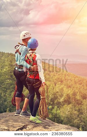 A Couple Of Climbers With Ropes On A Cliff Top. Mountain Climbing Equipment