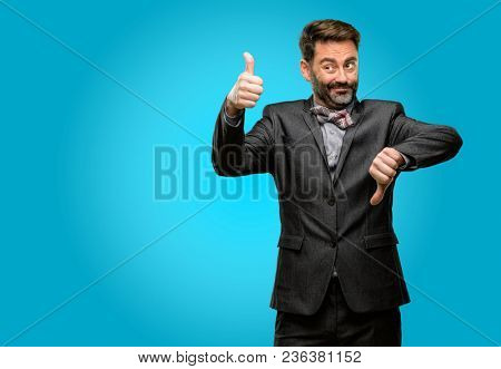 Middle age man, with beard and bow tie confused with thumbs up and down, trying to take a decision expressing doubt and frustration