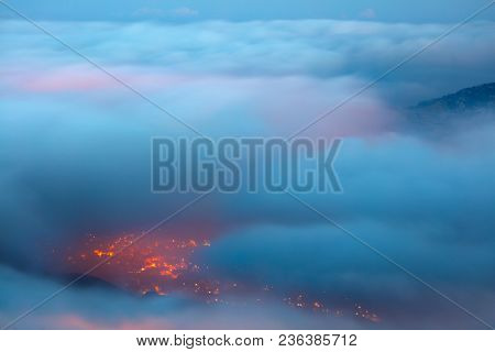 Bird's eye view on Faraya mountain, Lebanon, amazing view from above through clouds on mountainous city, glowing lights from the homes windows at night