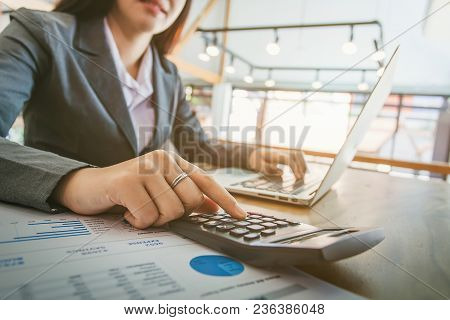 Business Women Using Calculator And Working In Office With Documents Financia