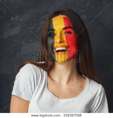 Portrait Of Happy Woman With The Flag Of Belgium Painted On Her Face. Football Or Soccer Team Fan, S