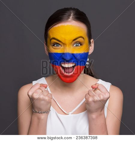 Portrait Of Happy Woman With The Flag Of Columbia Painted On His Face. Football Or Soccer Team Fan, 