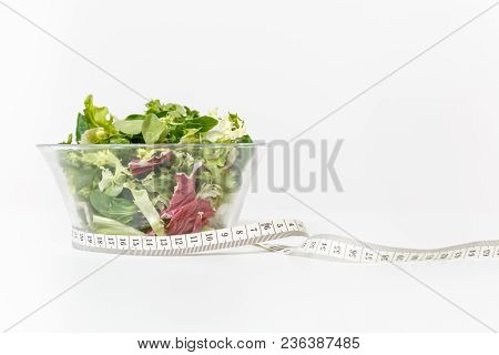 Close Up Green Vegetables Salad In Glass Bowl, Tailor Measuring Tape Isolated On White Background. P