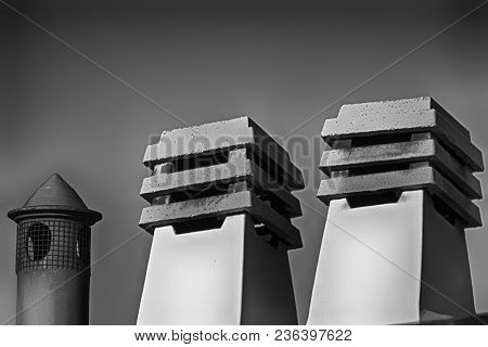Stone Square Chimney On The Roof In Sunny Weather.