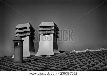 Stone Square Chimney On The Roof In Sunny Weather.