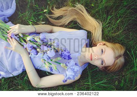 Attractive Young Girl With Blonde Dren Hair And Natural Make-up Smelling Blue Purple Iris Flowers Ly
