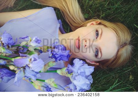 Attractive Young Girl With Blonde Dren Hair And Natural Make-up Smelling Blue Purple Iris Flowers Ly