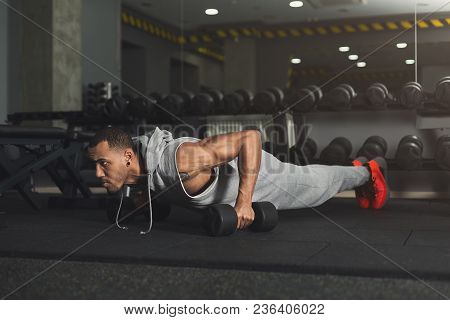 Young African-american Man Workout In Fitness Club. Black Guy Making Plank Or Push Ups Exercise On D