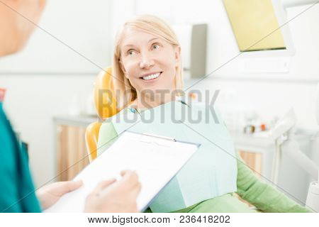 Smiling patient listening to her dentist recommendations after chack-up or healing teeth